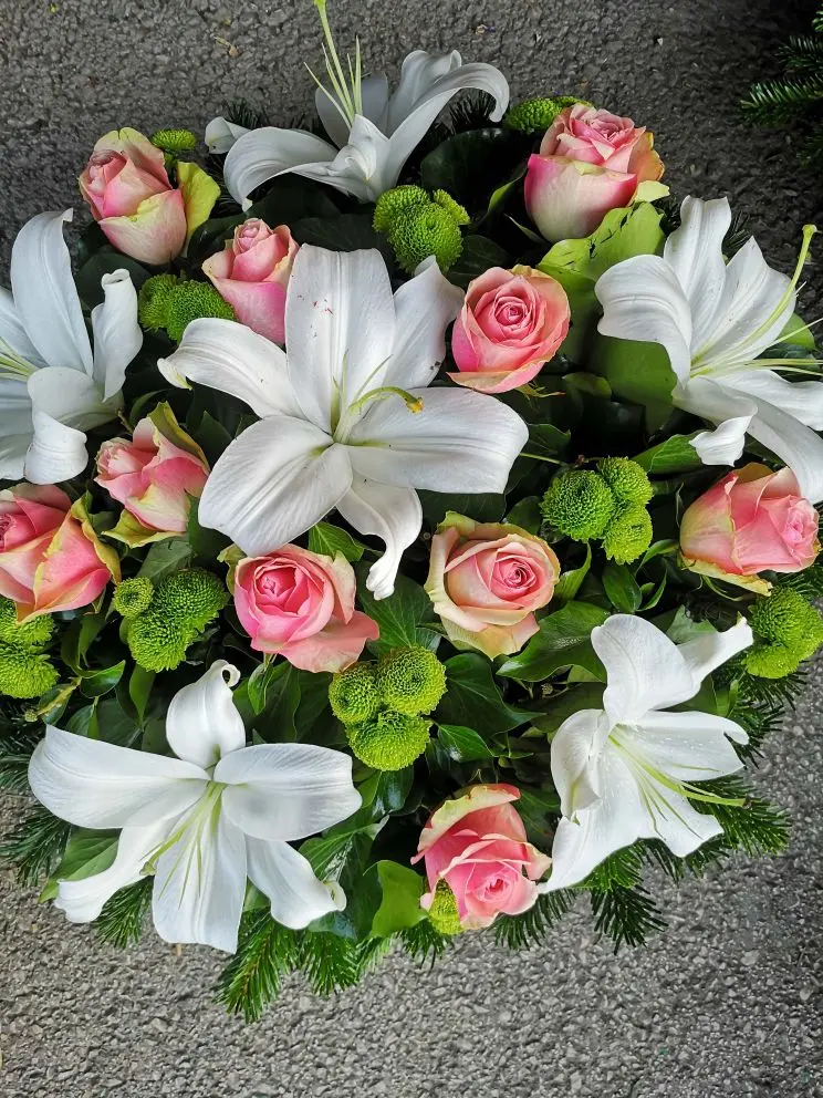 Fekvő koszorú fehér liliommal, rózsaszín rózsával és zöld krizantémmal – 60–80 cm. Friss, elegáns temetési virágkompozíció. Nefelejcs Virágüzlet.